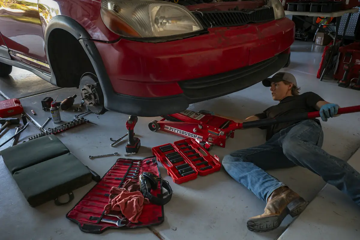 Illustrative photo of a person beside a car in a garage. Not a West Auto project.